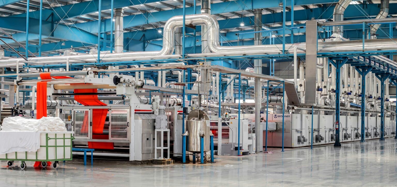 Machinery and pipework running through an industrial factory floor