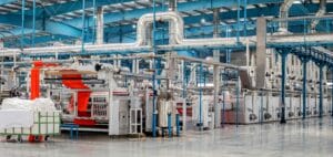 Machinery and pipework running through an industrial factory floor