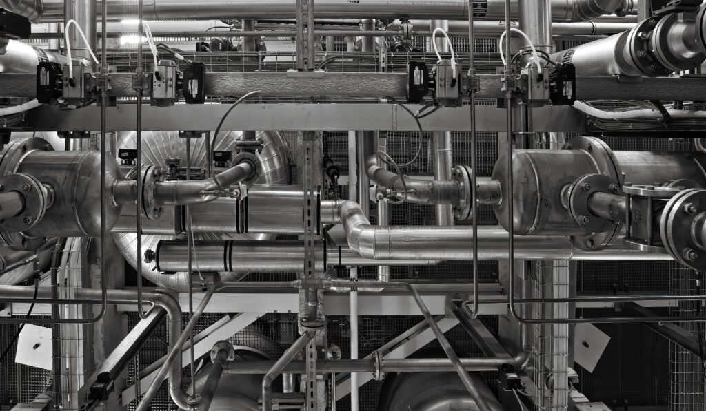 A stainless steel and red industrial machine on a production floor