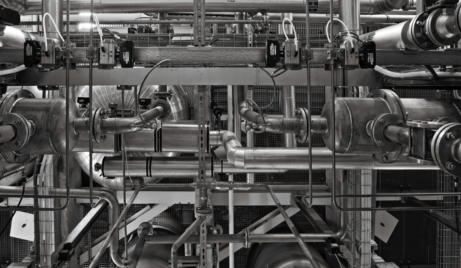 A stainless steel and red industrial machine on a production floor