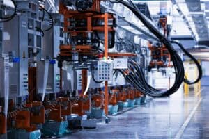 A line of electrical control equipment running along a factory floor